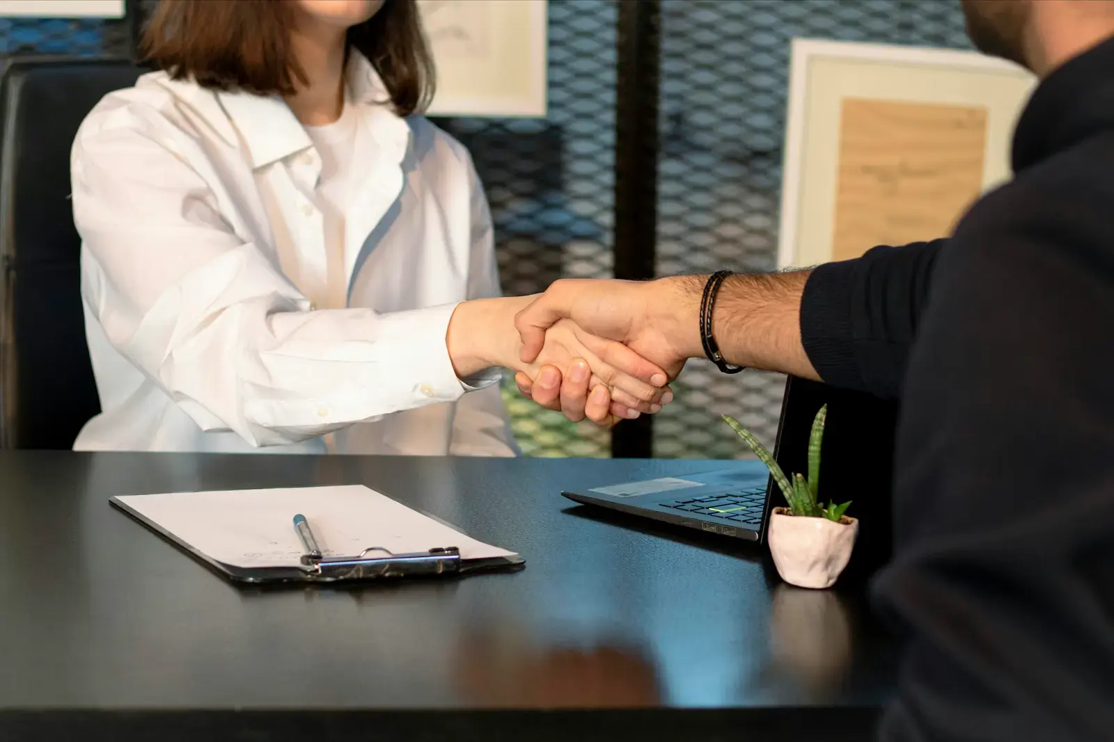 Poignée de main au-dessus d’un contrat posé sur un bureau