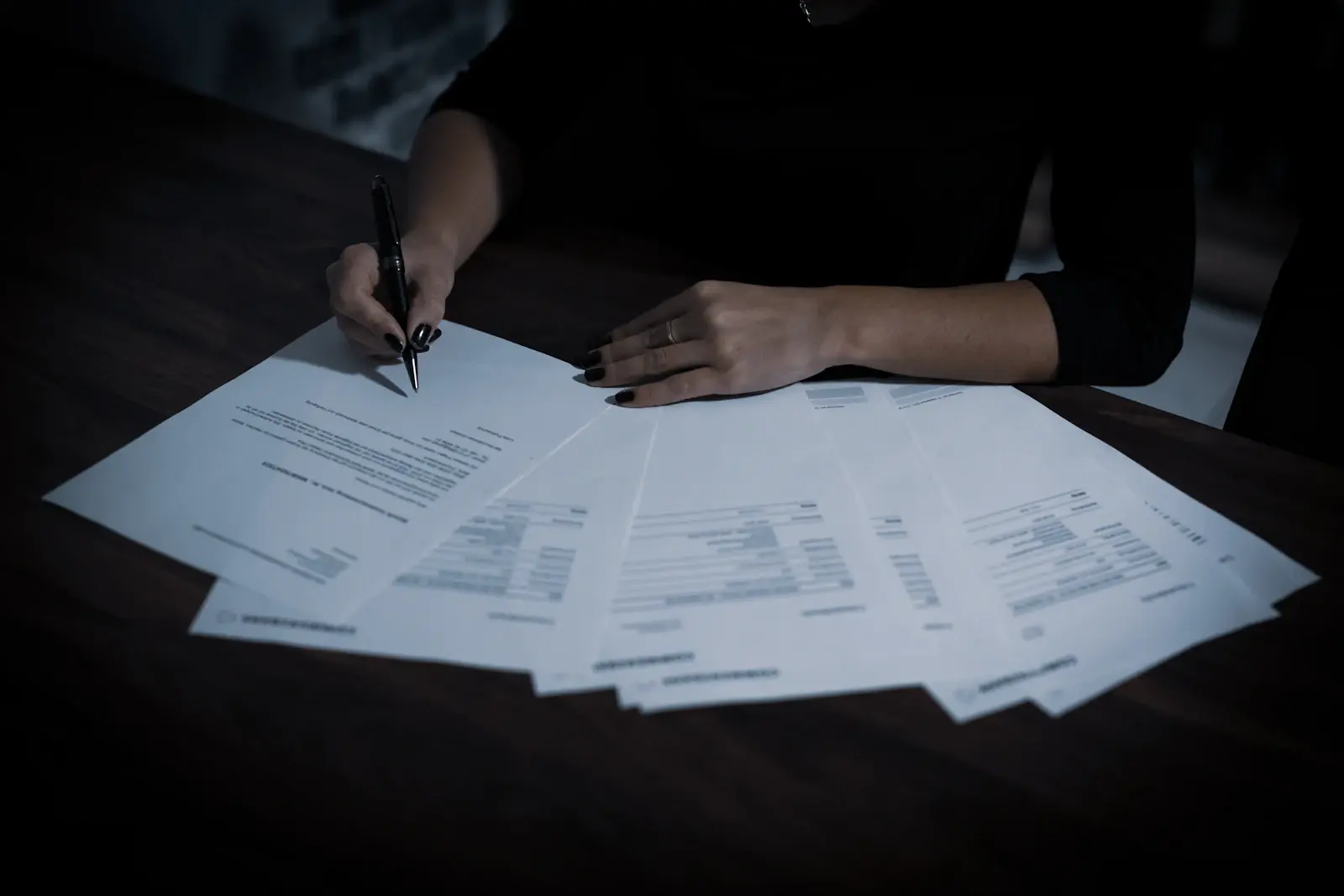 Mains qui parcourent un dossier de documents sur un bureau
