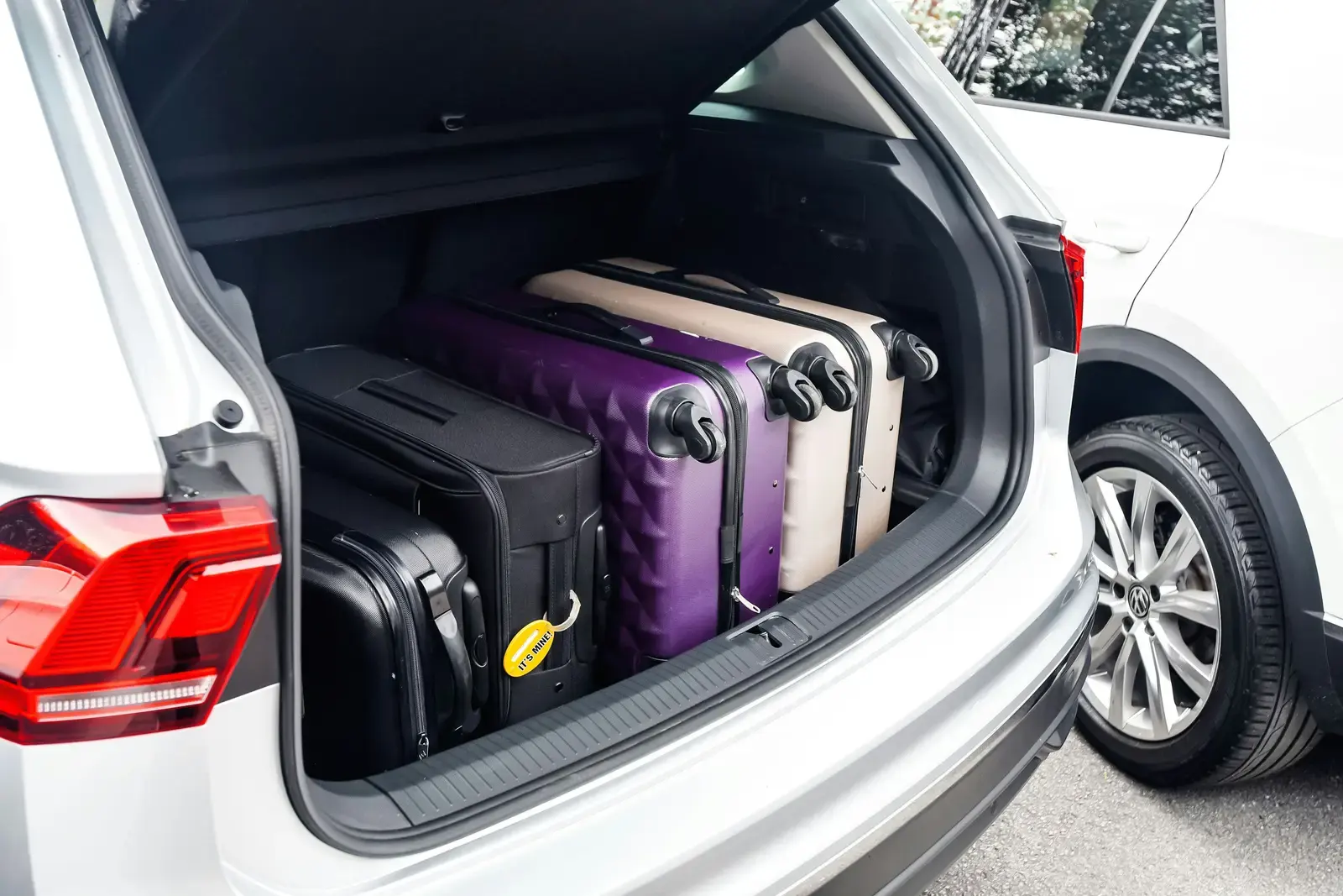Valises rangées dans le coffre ouvert d’un SUV blanc